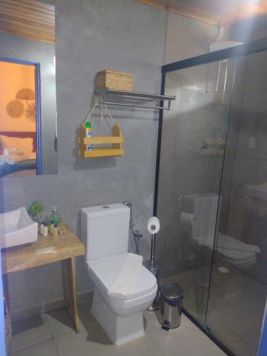 a bathroom with a toilet and a glass shower at Tapiri Pousada - Rota Ecológica dos Milagres in São Miguel dos Milagres