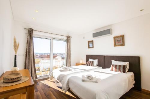 um quarto com duas camas e uma janela grande em Sunset T3 - by Smarthomes em São Martinho do Porto
