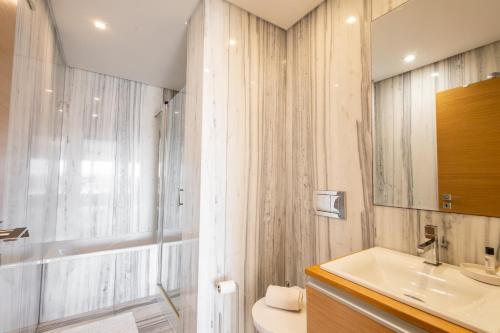 um banheiro com uma pia, um vaso sanitário e um espelho em Sunset T3 - by Smarthomes em São Martinho do Porto