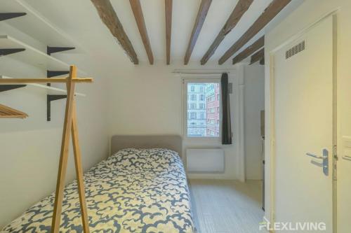 une petite chambre avec un lit et une fenêtre dans l'établissement Flexliving - studio - Lacépède, à Paris