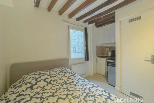 une petite chambre avec un lit et une fenêtre dans l'établissement Flexliving - studio - Lacépède, à Paris