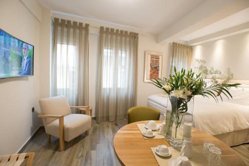 una habitación con una cama y una mesa con flores. en Villa Vilielmini en Ioánina