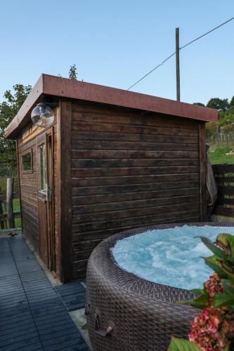 a wooden building with a hot tub in front of it at Agriturismo Terra e Cielo in Serra Riccò