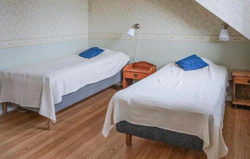 a room with two beds and a night stand with two beds at 5 Bedroom Amazing Home In Kilsmo in Kilsmo