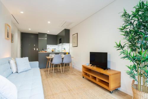 a living room with a blue couch and a tv at Stylish & Bright Flat with Balcony by HostWise in Matosinhos