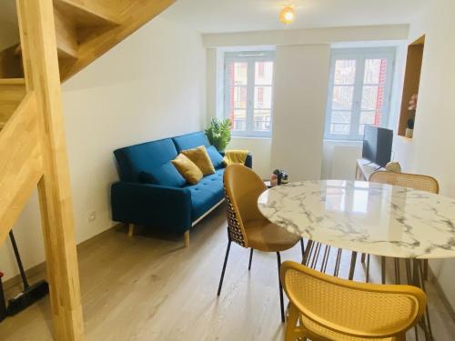 un salon avec un canapé bleu et une table dans l'établissement La MADELEINE, à Rodez