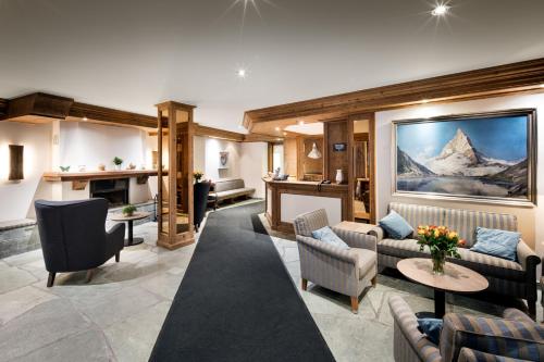 Una sala de estar con sofás y chimenea. en Hotel Butterfly, en Zermatt