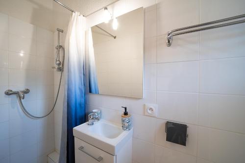 une salle de bain blanche avec un lavabo et une douche dans l'établissement Studio des Thermes - A 200m des Thermes, à Amélie-les-Bains-Palalda
