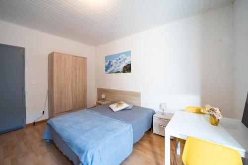 une chambre avec un lit, une table et un bureau dans l'établissement Studio des Thermes - A 200m des Thermes, à Amélie-les-Bains-Palalda