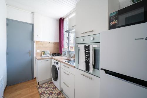une cuisine avec un lave-linge et un lave-linge dans l'établissement L'Écrin des Bains - A 200m des Thermes, à Amélie-les-Bains-Palalda