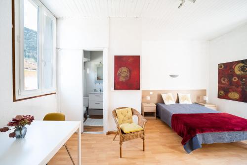 une chambre avec un lit et une chaise dans l'établissement L'Écrin des Bains - A 200m des Thermes, à Amélie-les-Bains-Palalda