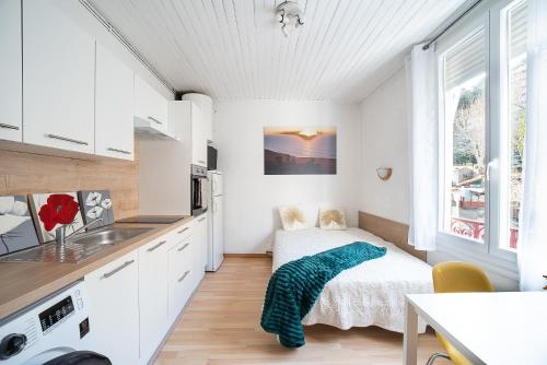 - une petite cuisine blanche avec un lit et un évier dans l'établissement Le Bain d’Amélie - A 200m des Thermes, à Amélie-les-Bains-Palalda