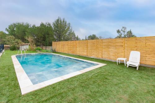 une cour avec une piscine et une clôture en bois dans l'établissement Le Coteau Ensoleillé - Climatisée avec piscine, à Carcassonne