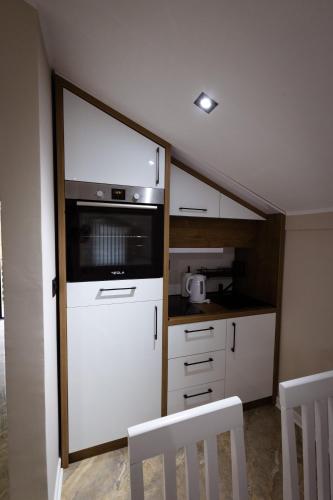 a small kitchen with a stove and a microwave at Vila Sofija Banja Vrujci in Gornja Toplica