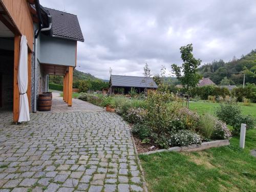 a brick walkway next to a house with a garden at ASKAHA Glamping in Oskava