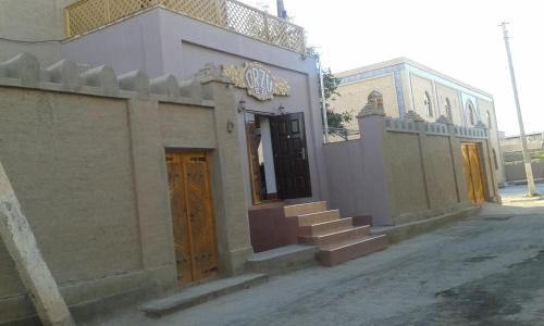 a building with a staircase in front of it at Guest House Orzu in Khiva
