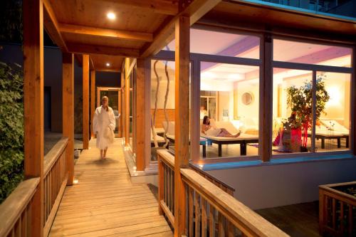a woman walking down a wooden walkway in a house at ROBINSON Landskron in Landskron