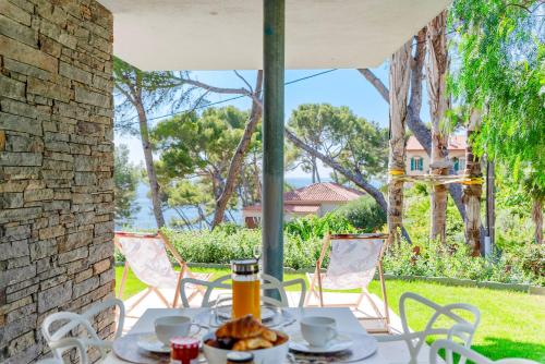 - une table et des chaises sur la terrasse couverte d'une maison dans l'établissement Tokoto Rez de jardin Vue mer, à La Seyne-sur-Mer