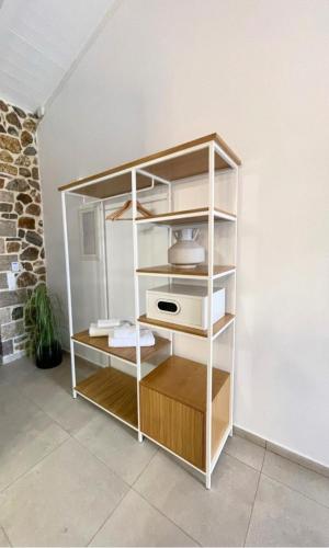a white book shelf with a microwave on it at Trocadero Ermioni Suites in Ermioni