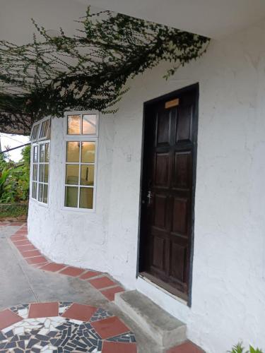 a door on the side of a house with a window at The Bala's Holiday Chalet in Cameron Highlands