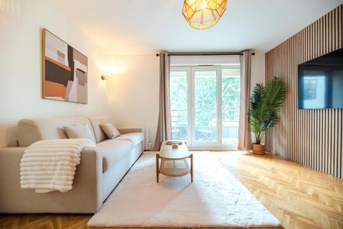un salon avec un canapé et une table dans l'établissement CIA - Flat with Balcony in East Paris, Buttes Chaumont, à Paris