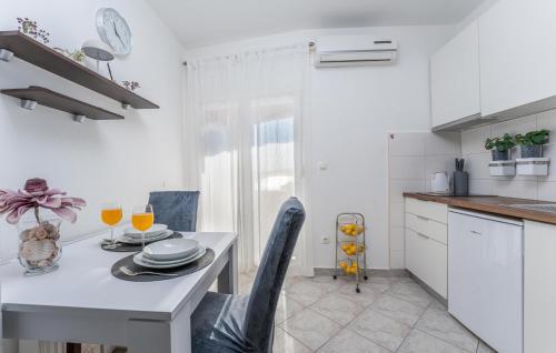 a kitchen with a table and chairs and a white kitchen at Stunning Apartment In Turanj in Turanj