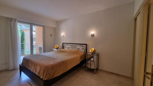 une chambre avec un lit et une grande fenêtre dans l'établissement Elégant 3 pièces au Port de la Figueirette, à Théoule-sur-Mer