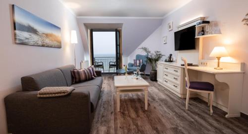 a living room with a couch and a table at Hotel Wilhelmshöhe in Warnemünde