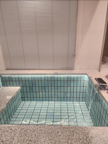 a bathroom with a tiled tub with a window at Gyeong-ju Stayangim in Gyeongju