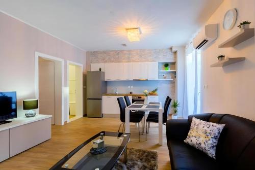 ein Wohnzimmer mit einer Couch und einem Tisch in der Unterkunft Apartman Candy Split with jacuzzi and parking place in Split
