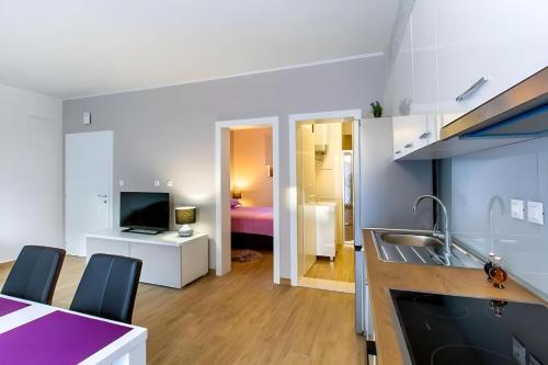 eine Küche und ein Wohnzimmer mit einem Waschbecken und einem TV in der Unterkunft Apartman Candy Split with jacuzzi and parking place in Split