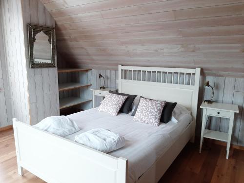 une chambre avec un lit blanc avec des oreillers dans l'établissement La Moussette, à Jullouville