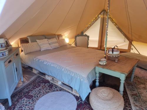 a bedroom with a bed in a tent at Tente glamping "bluebird" à la Ferme de la Chevêche in Fosses-La-Ville