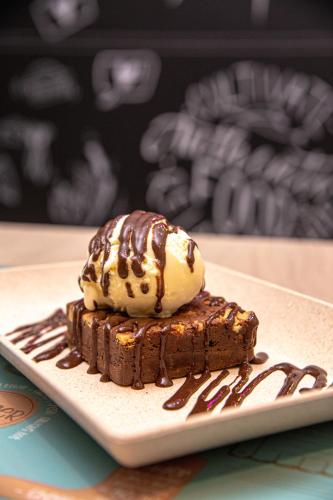a piece of chocolate dessert with ice cream on top at ibis Styles Goiania Marista in Goiânia