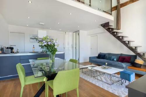 - un salon avec une table en verre et des chaises vertes dans l'établissement Apartement Forville by Halldis, à Cannes