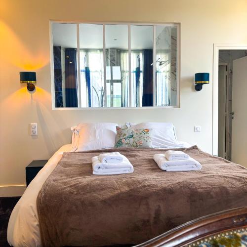 a bedroom with a bed with two towels on it at La Demeure d'Élodie in Épernay