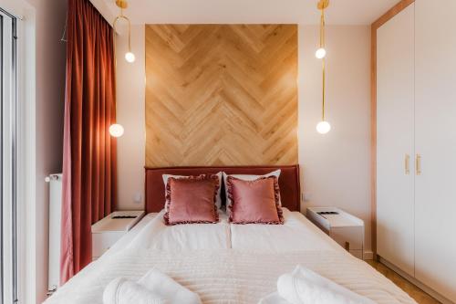 ein Schlafzimmer mit einem Bett mit einem hölzernen Kopfteil in der Unterkunft Apartament przy Plaży z darmowymi rowerami 212 by Perłowa Przystań Rent in Sianożęty