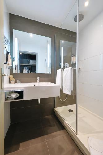 a bathroom with a sink and a shower at Mercure Grenoble Centre Porte des Alpes in Grenoble