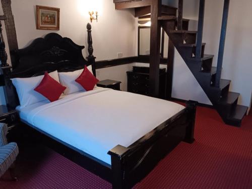 a bedroom with a large bed with red pillows at The Bala's Holiday Chalet in Cameron Highlands