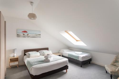 une chambre avec deux lits et une chaise dans l'établissement Cap Vauban - Duplex à 200m de la plage, à Saint-Malo