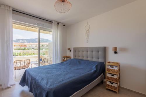 une chambre avec un lit et un balcon dans l'établissement Le Palmier - Plage à 5 min vue mer et montagne, à Lumio