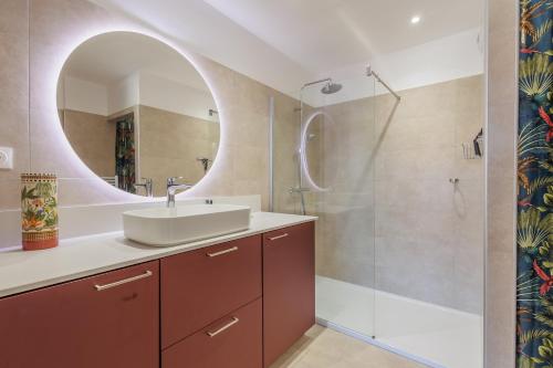 une salle de bain avec un lavabo et un miroir dans l'établissement Le Palmier - Plage à 5 min vue mer et montagne, à Lumio