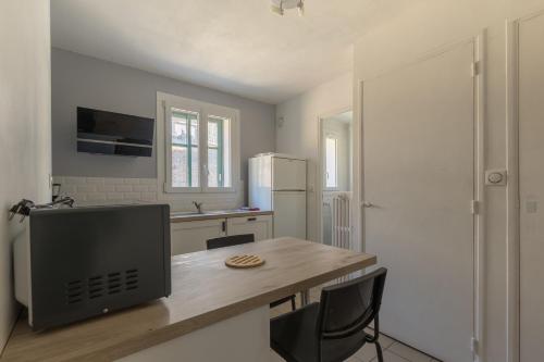 Il comprend une cuisine avec un bureau et une télévision. dans l'établissement Le Forest - parking privé vue montagne proche lac, à Savines