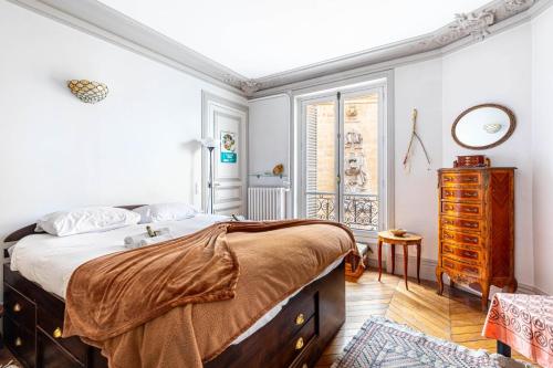 une chambre avec un lit, une commode et une fenêtre dans l'établissement GuestReady - Charming Vintage with Iconic Views, à Paris