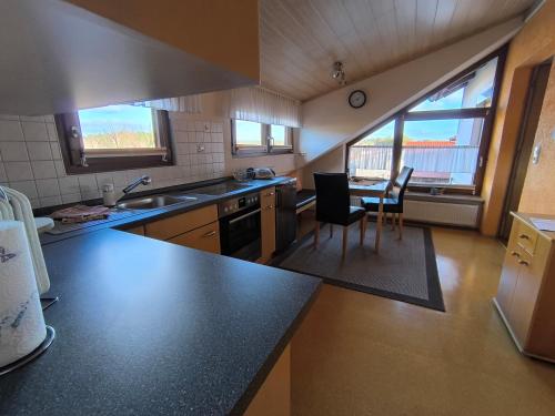 a kitchen with a counter and a table and chairs at Ferienhaus Brütting in Pottenstein