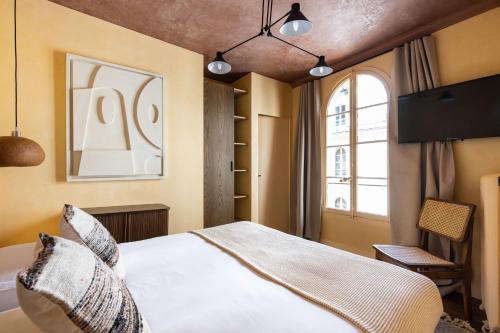 une chambre avec un lit et une fenêtre dans l'établissement NoChichi Collections - Grands Boulevards, à Paris