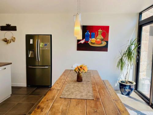 une cuisine avec une table en bois et un réfrigérateur dans l'établissement Villa Ker Sanmamaleo près de la plage - 4 chambres, 3 salles de bain, Wifi, animaux acceptés - FR-1-542-29, à Pleumeur-Bodou