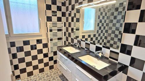 une salle de bain avec deux lavabos et un miroir dans l'établissement Les Oyats, à Sainte-Maxime