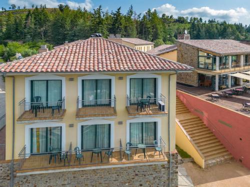 a building with tables and chairs on the balcony at Vilar Rural De Sant Hilari Sacalm by Serhs Hotels in Sant Hilari Sacalm