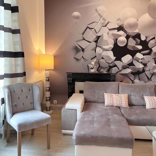 a living room with a couch and a chair at La Demeure d'Elodie in Épernay